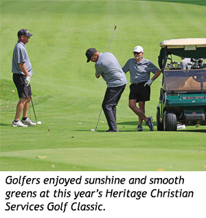 Three golfers on a course near a golf cart during the Heritage Christian Services Golf Classic.