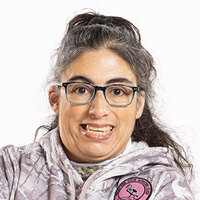 A woman wearing glasses and a camouflage patterned sweatshirt.