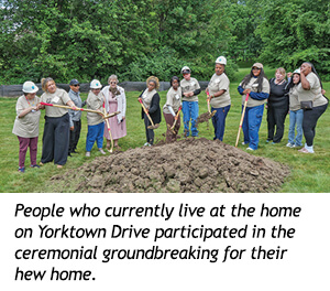 A group of people in hard hats performs a ceremonial groundbreaking in a dirt plot for the Fall 2026 Spirit Newsletter.